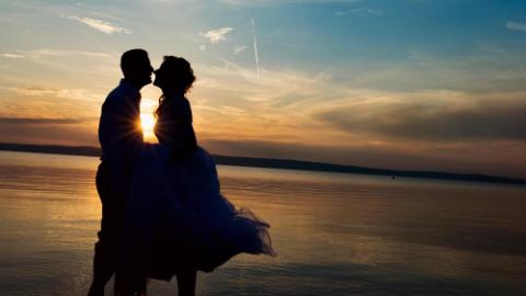 young wedding couple standing on the beach