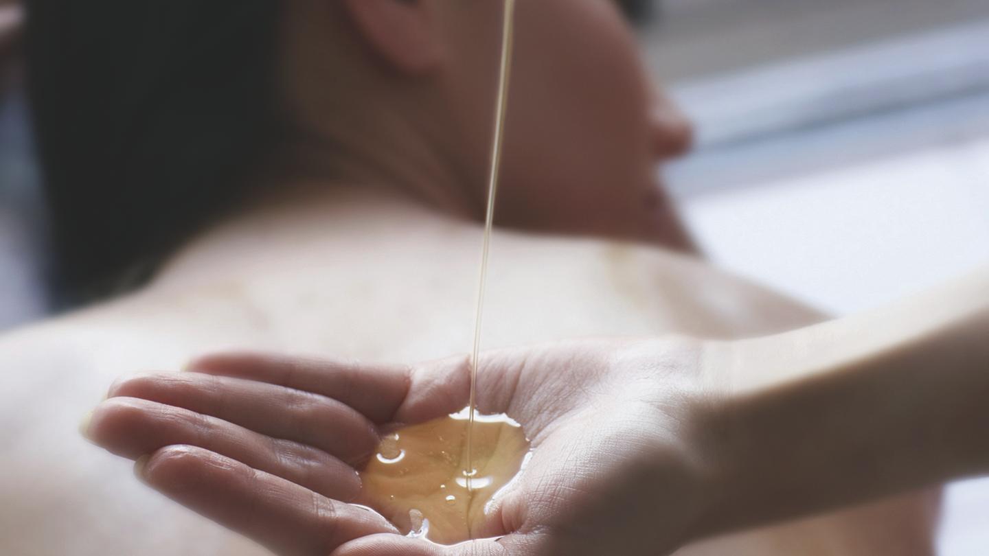 female getting a hot stone massage poolside